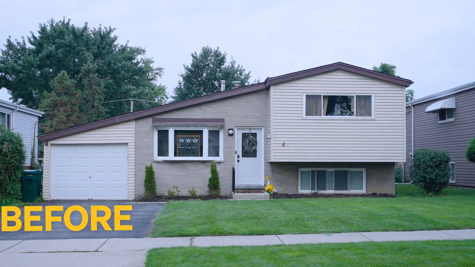 Before: white garage door and unfinished garden beds