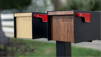 Two Adoorn Wood Series Post Mount mailboxes side by side at the curb, one in white oak and one in walnut, the engraved 'mail' wordmark and red flag visible on each.