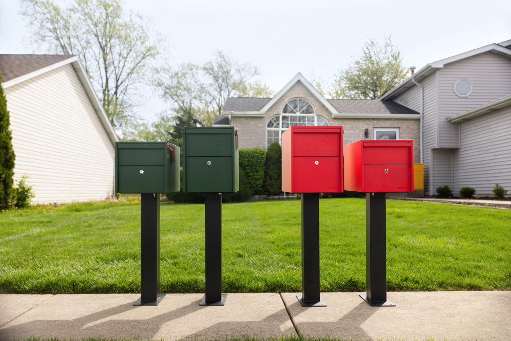 Adoorn Small and Large post mount mailboxes shown together, in Forest Green and Red Red, at a distance