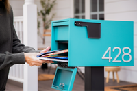 A homeowner uses an Adoorn Aegean Locking Post Mount mailbox at the curb, lifting the door to retrieve mail through the secure slot.