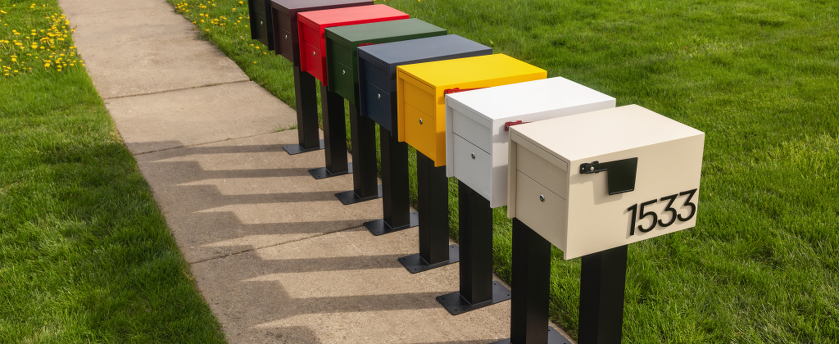 The Adoorn Post Mount range, multiple colors lined up curbside on a residential pathway, illustrating the modern post mount lineup that anchors this guide